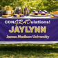 Party table edge — purple & gold banner draped over a decorated graduation table