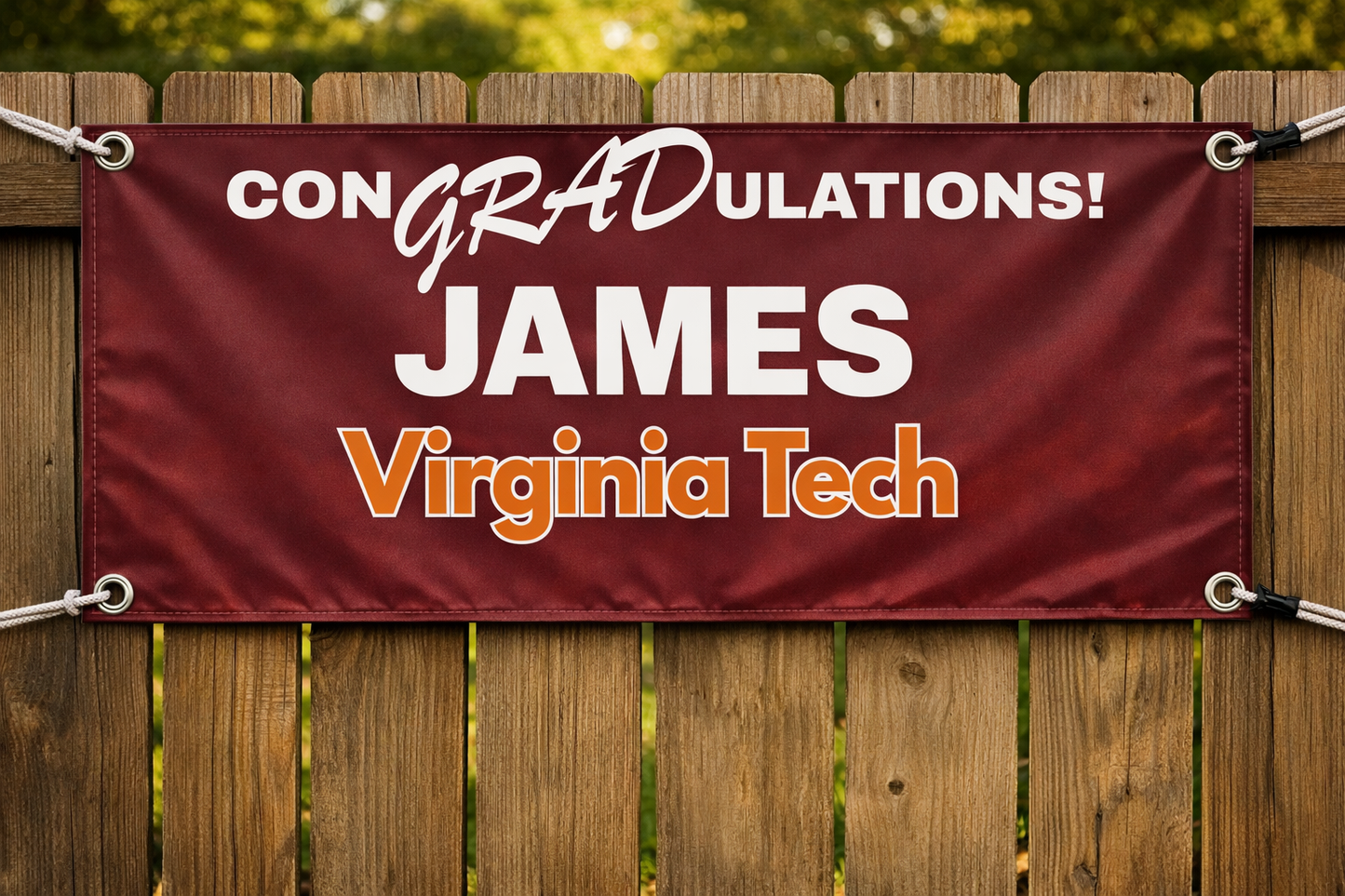 Wooden fence shot with the banner, grommets, and rope against the weathered wood. ConGRADulations James Virginia Tech in Maroon and Burnt Orange